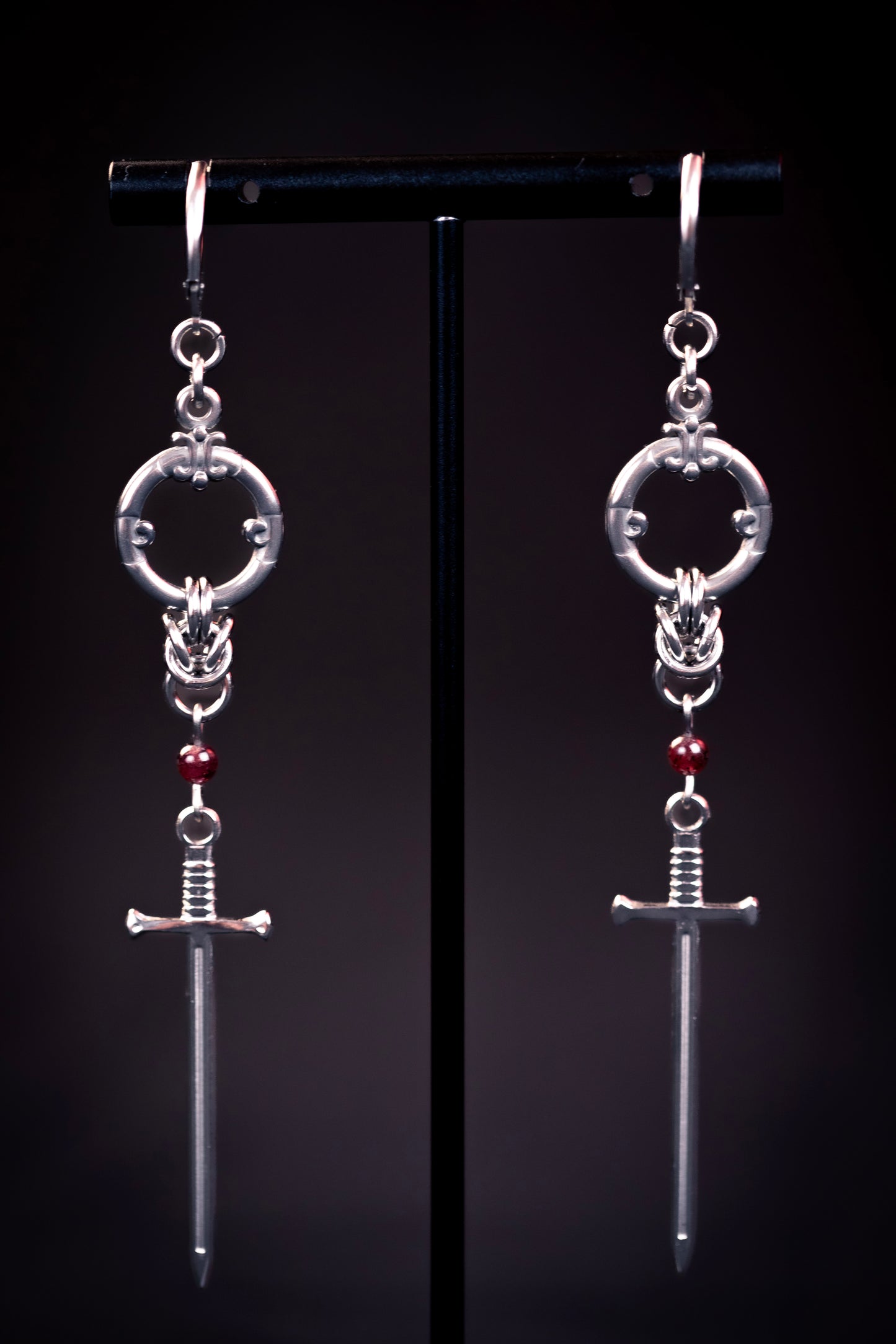 ARYA | Chainmail Earrings
Stainless steel chainmail earrings with a garnet stone and a silver sword