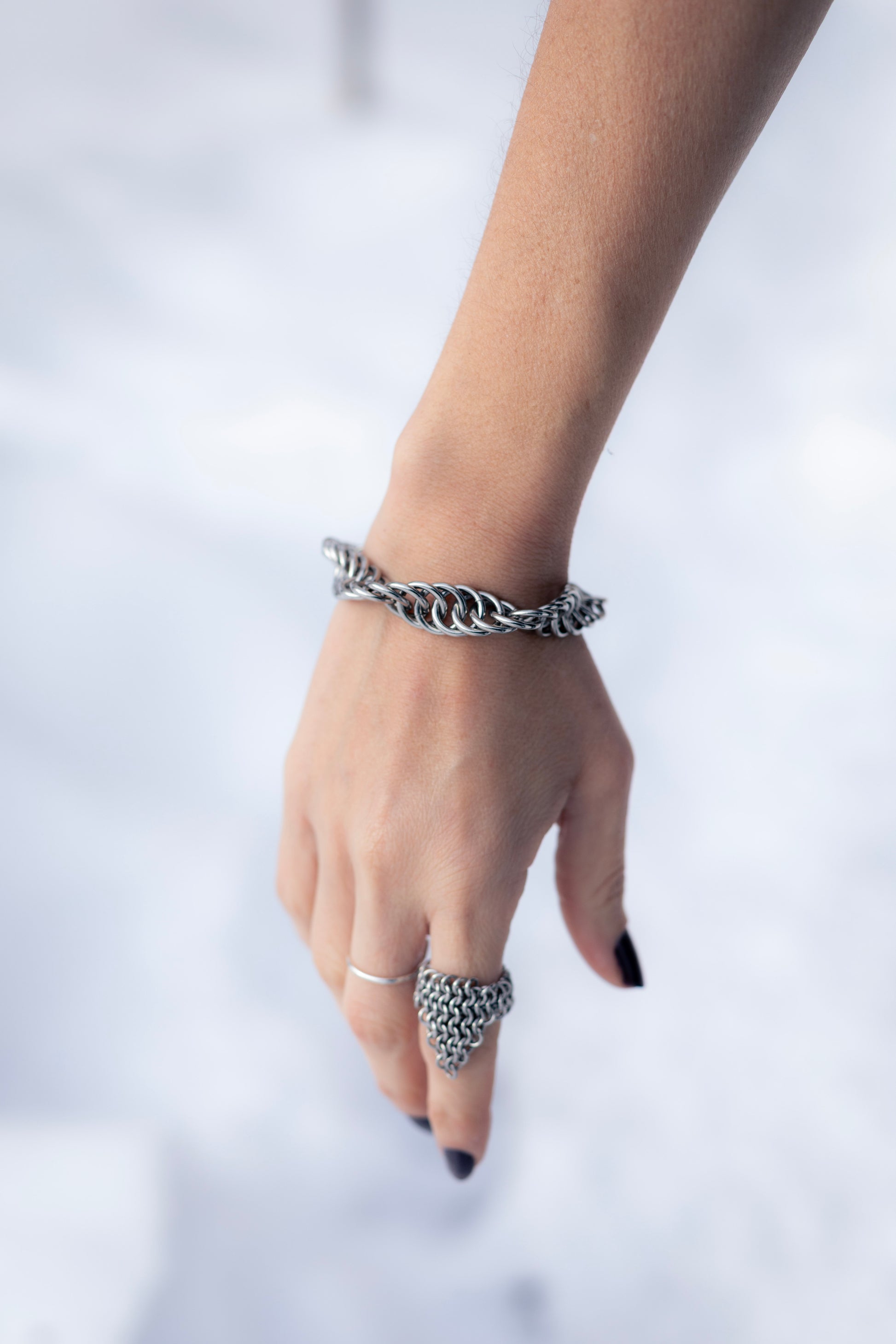 GAÏA | Chainmail Bold Bracelet
Hand wearing a silver chain bracelet on a light background