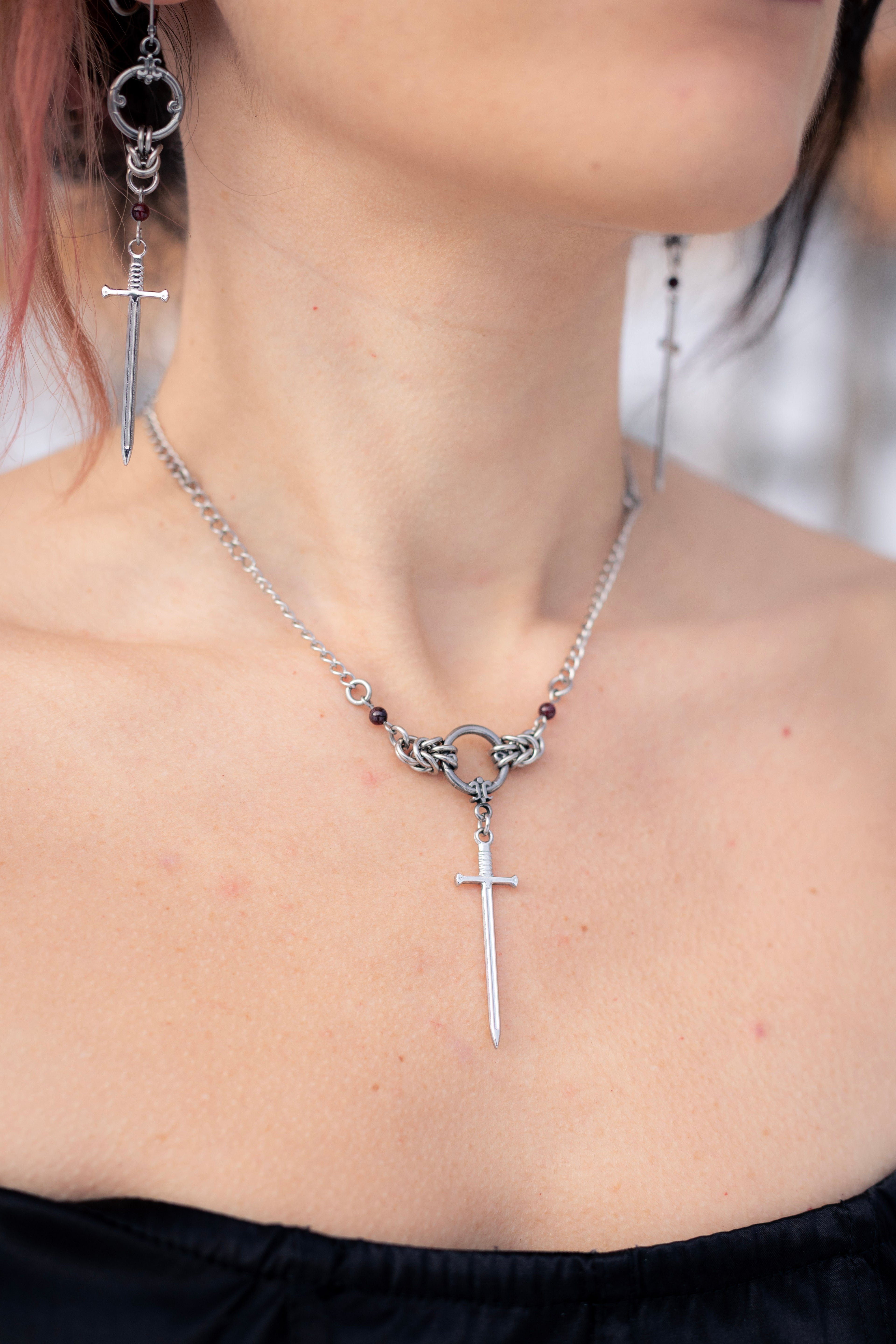 ARIA | Chainmail necklace
Stainless steel chainmail necklace with two garnet stones and a sword