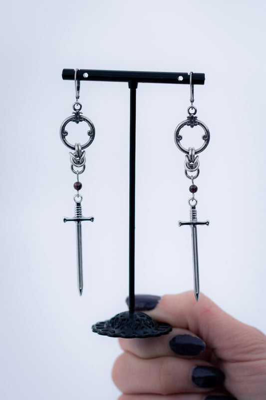 ARIA | Chainmail Earrings
Stainless steel chainmail earrings with a garnet stone and a silver sword